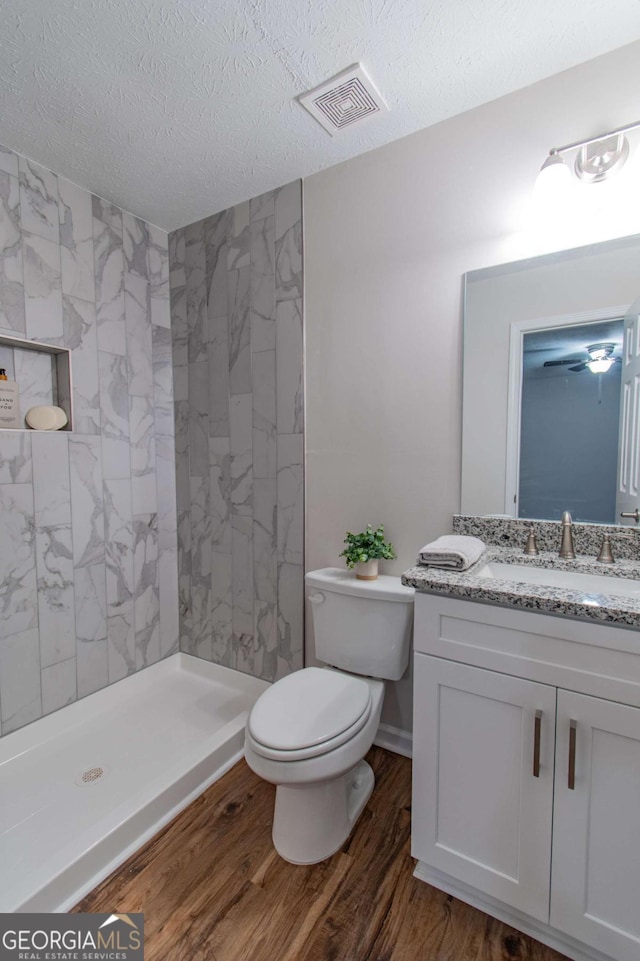 909 Shiloh Ridge Run NW, Kennesaw, GA 30144 - full bathroom featuring vanity, wood finished floors, tiled shower, and a textured ceiling