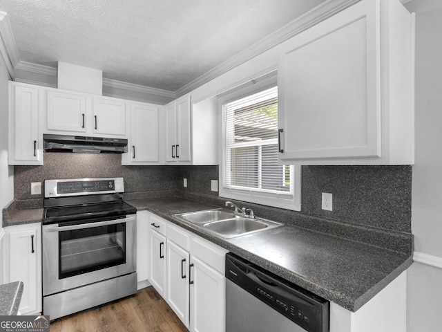 4720 Hull Rd SE, Conyers, GA 30094 - kitchen with appliances with stainless steel finishes, under cabinet range hood, crown molding, dark countertops, and tasteful backsplash