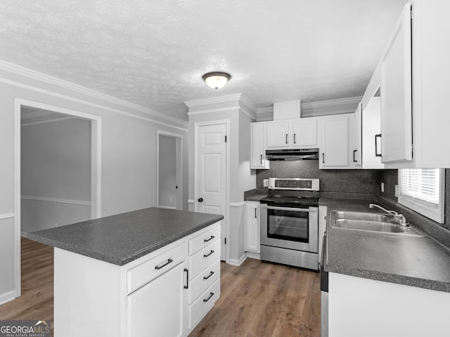 4720 Hull Rd SE, Conyers, GA 30094 - kitchen with electric range, under cabinet range hood, dark countertops, wood finished floors, and crown molding