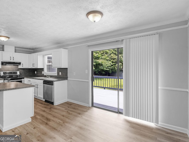 4720 Hull Rd SE, Conyers, GA 30094 - kitchen with stainless steel appliances, dark countertops, a textured ceiling, under cabinet range hood, and white cabinetry