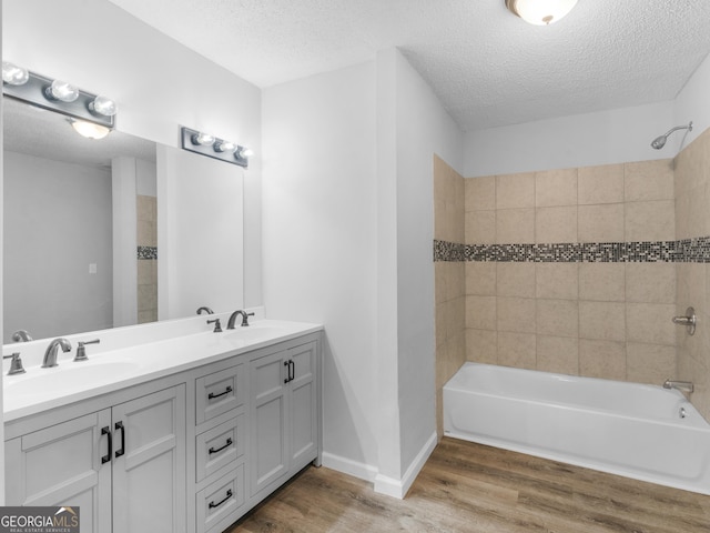 4720 Hull Rd SE, Conyers, GA 30094 - full bath with wood finished floors, double vanity, a textured ceiling, and bathing tub / shower combination