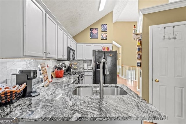 47 Powder Springs St, Hiram, GA 30141 - kitchen featuring light stone counters, black refrigerator with ice dispenser, range, lofted ceiling, and a textured ceiling