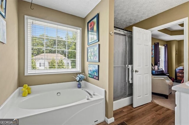 47 Powder Springs St, Hiram, GA 30141 - full bath with a bath, plenty of natural light, a stall shower, wood finished floors, and a textured ceiling