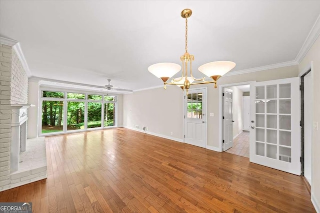 2179 Mountclaire Ct, Stone Mountain, GA 30087 - unfurnished living room featuring a chandelier, ceiling fan, hardwood / wood-style flooring, ornamental molding, and a fireplace