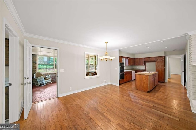 2179 Mountclaire Ct, Stone Mountain, GA 30087 - kitchen with a chandelier, open floor plan, light wood-type flooring, brown cabinetry, and pendant lighting