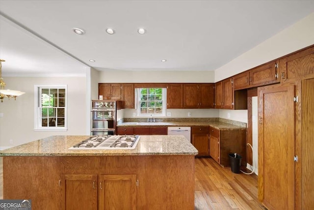 2179 Mountclaire Ct, Stone Mountain, GA 30087 - kitchen featuring white appliances, a center island, light wood-style flooring, light stone countertops, and ornamental molding