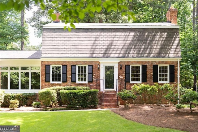 2179 Mountclaire Ct, Stone Mountain, GA 30087 - dutch colonial with a chimney, a front lawn, and brick siding
