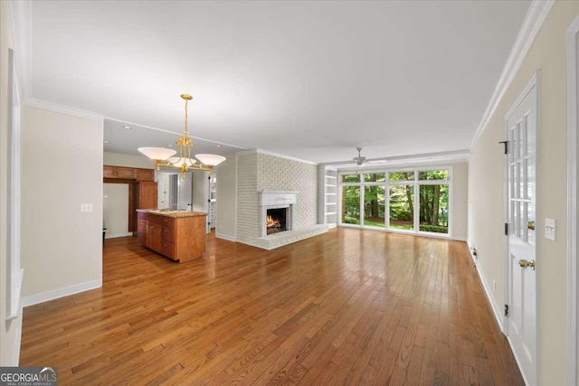 2179 Mountclaire Ct, Stone Mountain, GA 30087 - unfurnished living room featuring crown molding, a fireplace, wood-type flooring, ceiling fan, and a chandelier