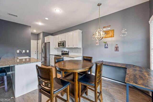 6422 Woodland Station Dr, Lula, GA 30554 - dining area with wood finished floors, a chandelier, and recessed lighting