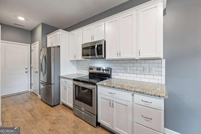 6422 Woodland Station Dr, Lula, GA 30554 - kitchen with stainless steel appliances, white cabinetry, decorative backsplash, and light stone countertops