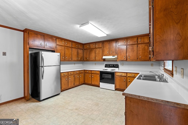 23-25 Sentry Oak Ct, Stockbridge, GA 30281 - kitchen with freestanding refrigerator, range with electric cooktop, under cabinet range hood, brown cabinets, and light floors