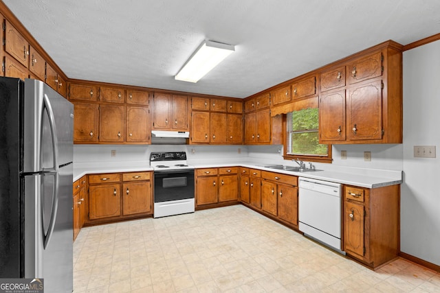 23-25 Sentry Oak Ct, Stockbridge, GA 30281 - kitchen featuring freestanding refrigerator, dishwasher, under cabinet range hood, range with electric stovetop, and brown cabinetry