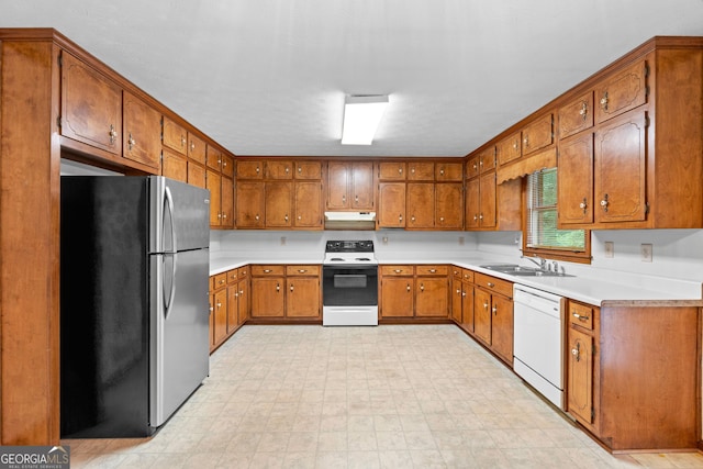 23-25 Sentry Oak Ct, Stockbridge, GA 30281 - kitchen with freestanding refrigerator, electric stove, white dishwasher, under cabinet range hood, and brown cabinetry