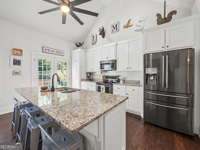 105 Crestview Dr, Jefferson, GA 30549 - kitchen featuring appliances with stainless steel finishes, a center island with sink, white cabinetry, dark wood-style floors, and high vaulted ceiling