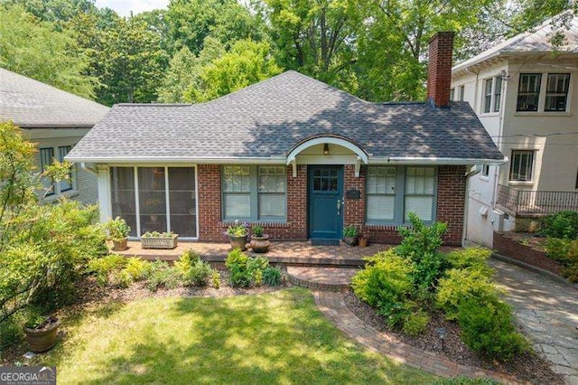 1300 N Ave NE, Atlanta, GA 30307 - view of front of home featuring brick siding, a chimney, a front lawn, and a shingled roof