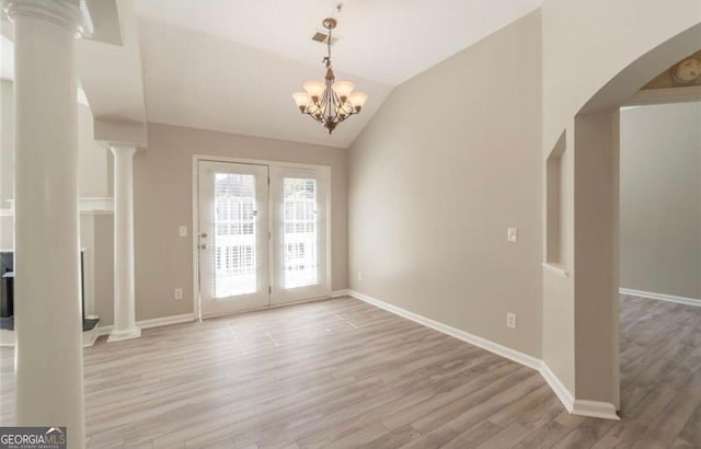 1392 Orchard Park Dr, Stone Mountain, GA 30083 - unfurnished dining area with light wood-style floors, lofted ceiling, arched walkways, decorative columns, and a chandelier