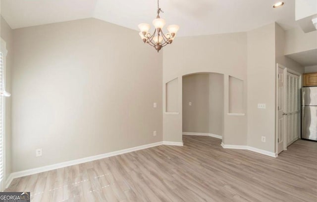 1392 Orchard Park Dr, Stone Mountain, GA 30083 - empty room featuring arched walkways, lofted ceiling, a chandelier, light wood-style floors, and plenty of natural light
