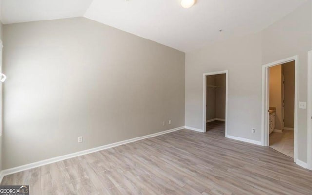 1392 Orchard Park Dr, Stone Mountain, GA 30083 - unfurnished bedroom featuring light wood-style floors, lofted ceiling, a walk in closet, a closet, and ensuite bathroom