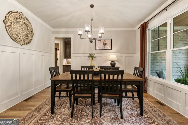 4395 Capstone Ct, Roswell, GA 30075 - dining room featuring a decorative wall, wood finished floors, a chandelier, and ornamental molding