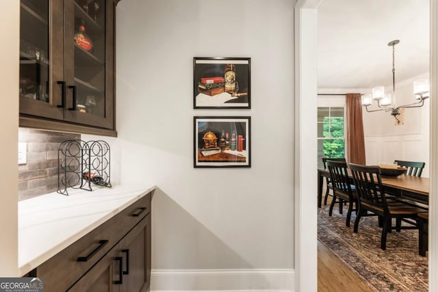 4395 Capstone Ct, Roswell, GA 30075 - bar with decorative backsplash, a chandelier, wood finished floors, and pendant lighting