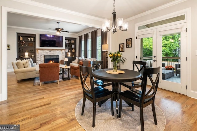 4395 Capstone Ct, Roswell, GA 30075 - dining area featuring ceiling fan, crown molding, a fireplace, light wood-style floors, and a chandelier