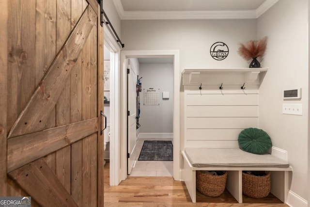 4395 Capstone Ct, Roswell, GA 30075 - mudroom featuring a barn door, ornamental molding, and light wood-type flooring