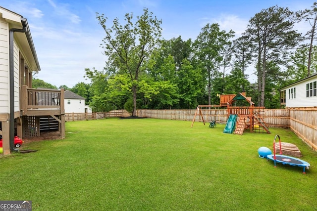 4395 Capstone Ct, Roswell, GA 30075 - fenced backyard with a playground, a trampoline, a deck, and view of scattered trees