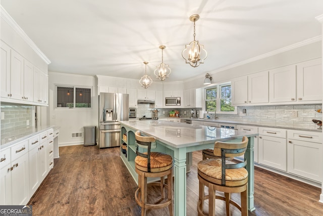 980 Casteel Rd, Powder Springs, GA 30127 - kitchen with appliances with stainless steel finishes, a chandelier, white cabinetry, and ornamental molding