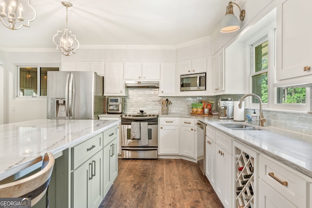 980 Casteel Rd, Powder Springs, GA 30127 - kitchen with stainless steel appliances, under cabinet range hood, a chandelier, white cabinets, and hanging light fixtures