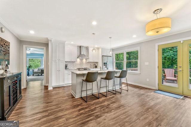 980 Casteel Rd, Powder Springs, GA 30127 - kitchen with wall chimney exhaust hood, appliances with stainless steel finishes, ornamental molding, a center island with sink, and white cabinets