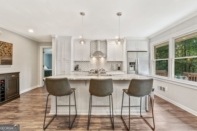 980 Casteel Rd, Powder Springs, GA 30127 - kitchen with stainless steel fridge with ice dispenser, wall chimney range hood, backsplash, an island with sink, and a kitchen breakfast bar
