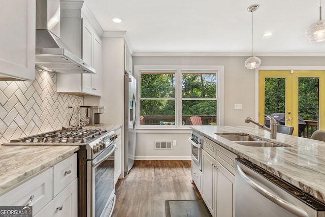 980 Casteel Rd, Powder Springs, GA 30127 - kitchen featuring appliances with stainless steel finishes, wall chimney range hood, dark wood-style flooring, decorative backsplash, and crown molding