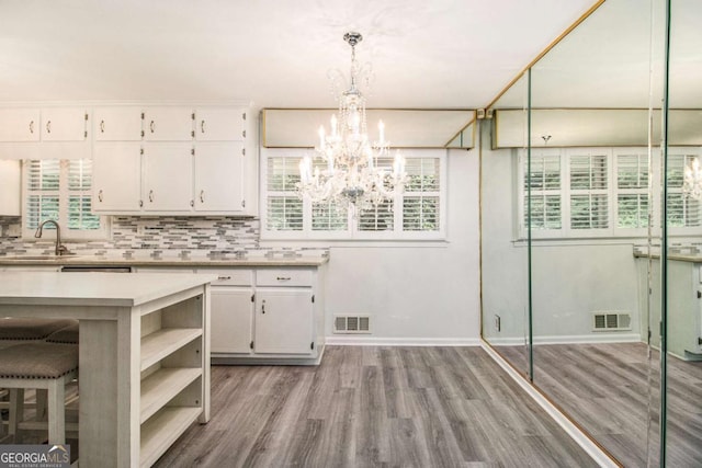 2983 Peek Rd NW, Atlanta, GA 30318 - kitchen with a chandelier, wood finished floors, white cabinetry, and light countertops