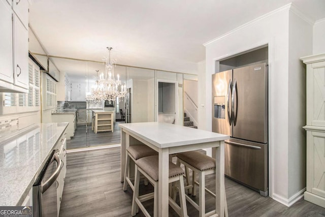 2983 Peek Rd NW, Atlanta, GA 30318 - kitchen featuring appliances with stainless steel finishes, dark wood-style flooring, light countertops, a chandelier, and a center island
