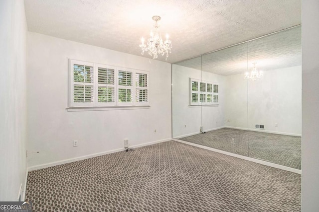 2983 Peek Rd NW, Atlanta, GA 30318 - carpeted empty room with a chandelier and a textured ceiling