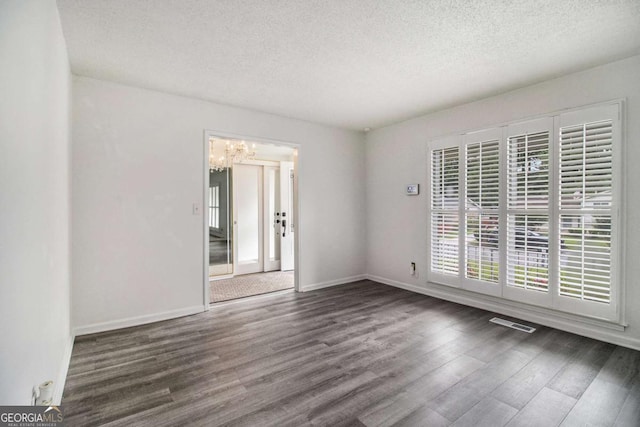 2983 Peek Rd NW, Atlanta, GA 30318 - empty room with a textured ceiling, wood finished floors, and a chandelier