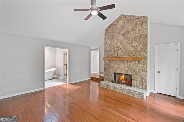 1279 Colony Pl, Marietta, GA 30068 - unfurnished living room featuring a ceiling fan, a stone fireplace, wood finished floors, and high vaulted ceiling