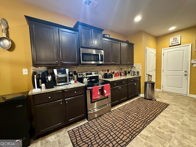 942 Amelia Dr, Byron, GA 31008 - kitchen with stainless steel appliances, decorative backsplash, light stone countertops, and recessed lighting