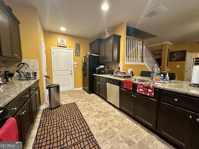 942 Amelia Dr, Byron, GA 31008 - kitchen with stainless steel dishwasher, black fridge with ice dispenser, backsplash, light stone countertops, and recessed lighting