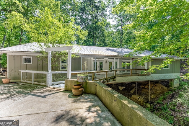 6567 Tahiti Way, Flowery Branch, GA 30542 - rear view of property featuring a sunroom, board and batten siding, a metal roof, and french doors