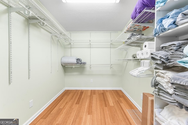 6567 Tahiti Way, Flowery Branch, GA 30542 - spacious closet with wood finished floors