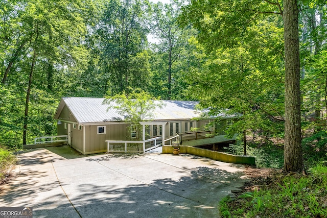 6567 Tahiti Way, Flowery Branch, GA 30542 - view of front facade featuring concrete driveway, a metal roof, and a wooden deck