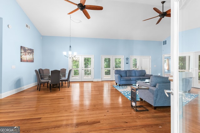 6567 Tahiti Way, Flowery Branch, GA 30542 - living area featuring french doors, a ceiling fan, high vaulted ceiling, light wood finished floors, and a chandelier