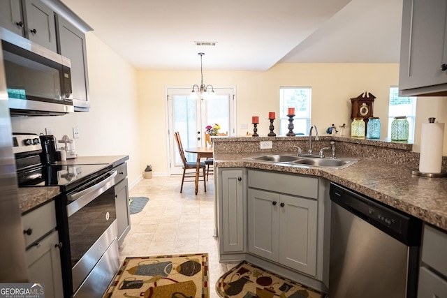 126 Savannah Way, Milner, GA 30257 - kitchen featuring appliances with stainless steel finishes, gray cabinets, a peninsula, a chandelier, and hanging light fixtures