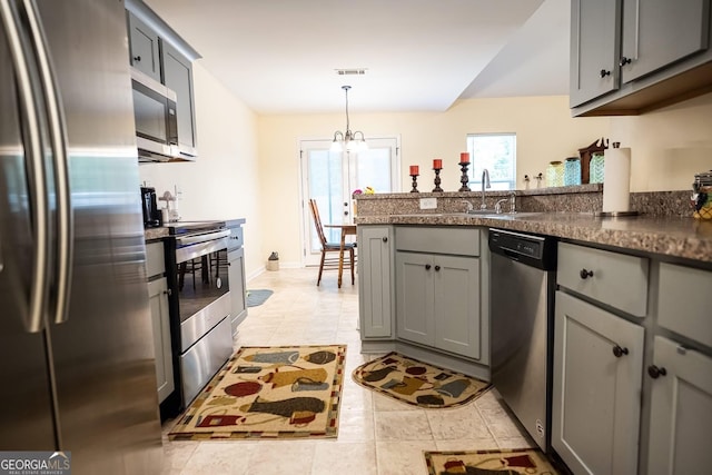 126 Savannah Way, Milner, GA 30257 - kitchen featuring stainless steel appliances, gray cabinetry, a peninsula, a chandelier, and hanging light fixtures