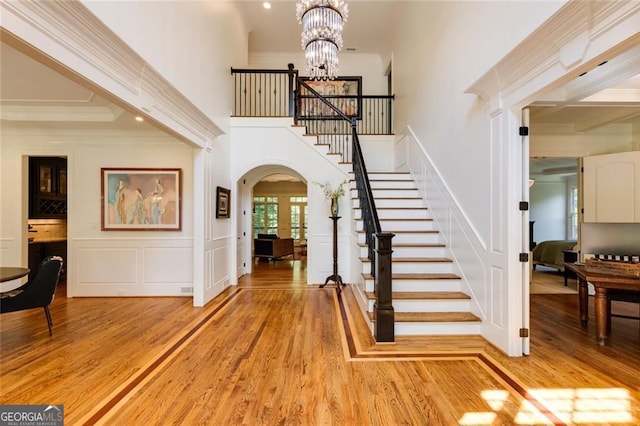 930 Shepards Ct, Roswell, GA 30075 - entrance foyer featuring a decorative wall, arched walkways, light wood-type flooring, a chandelier, and ornamental molding