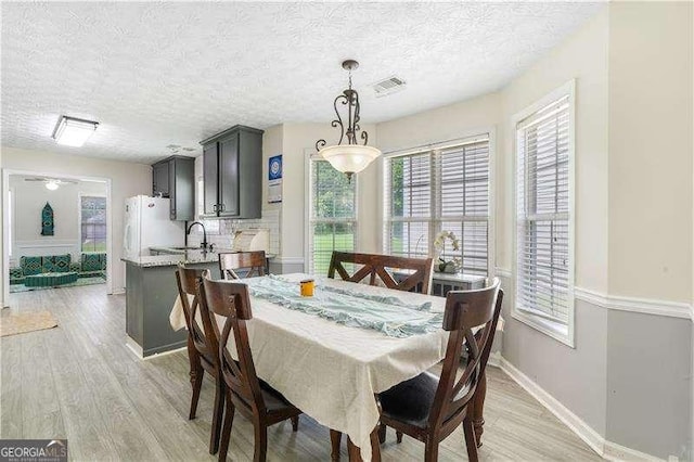3589 Garden Manor Dr, Loganville, GA 30052 - dining area with light wood-type flooring, a textured ceiling, and ceiling fan
