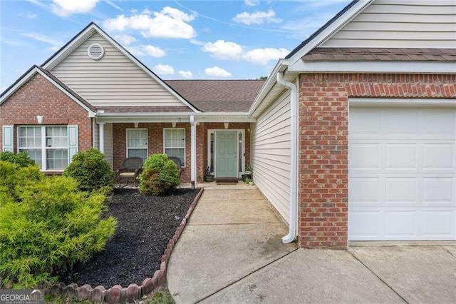 3589 Garden Manor Dr, Loganville, GA 30052 - doorway to property featuring brick siding, a garage, and driveway