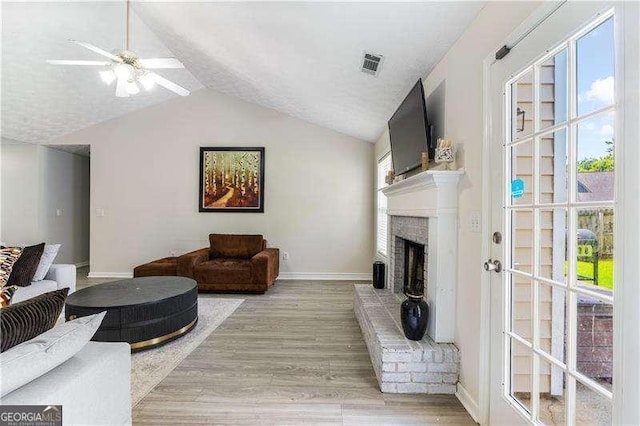 3589 Garden Manor Dr, Loganville, GA 30052 - living area with lofted ceiling, a fireplace, ceiling fan, and light wood-style flooring