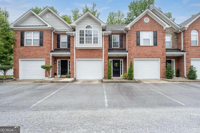 215 Morris Ln, Woodstock, GA 30188 - townhome / multi-family property with brick siding, an attached garage, and a standing seam roof